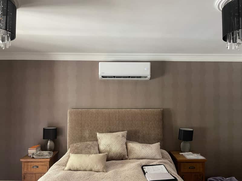 Air conditioning unit above a bed in a Newcastle upon Tyne bedroom