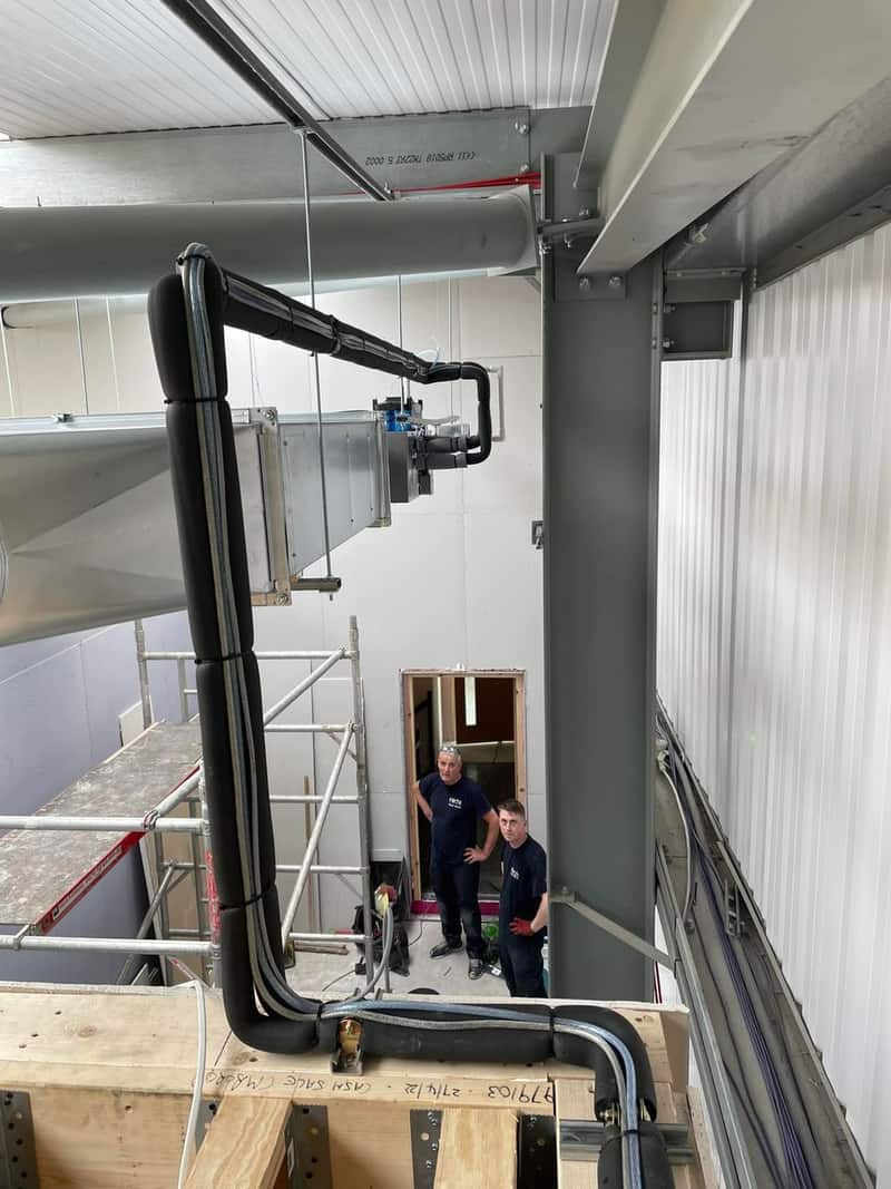 Engineers installing industrial air conditioning ductwork and pipework in Newcastle upon Tyne