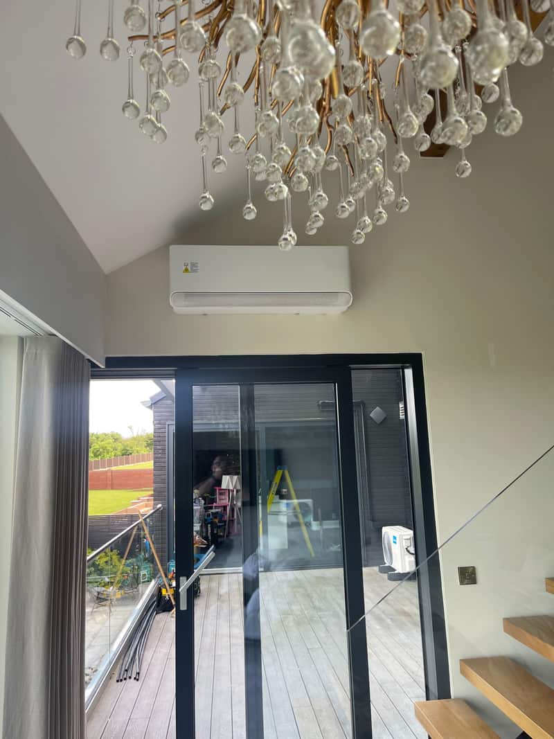 Wall-mounted air conditioner above sliding doors in a Newcastle upon Tyne garden room