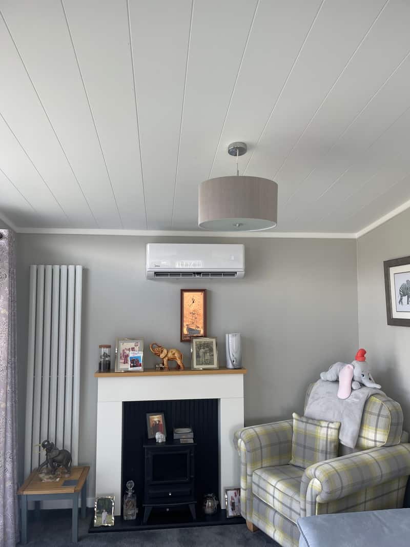 Wall-mounted air conditioning above a fireplace in a Newcastle upon Tyne living room